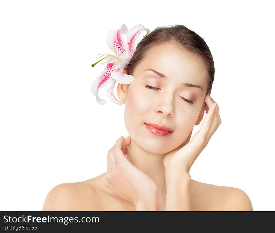 Studio portrait of a beautiful girl with a lily in her hair, the insulation on white.