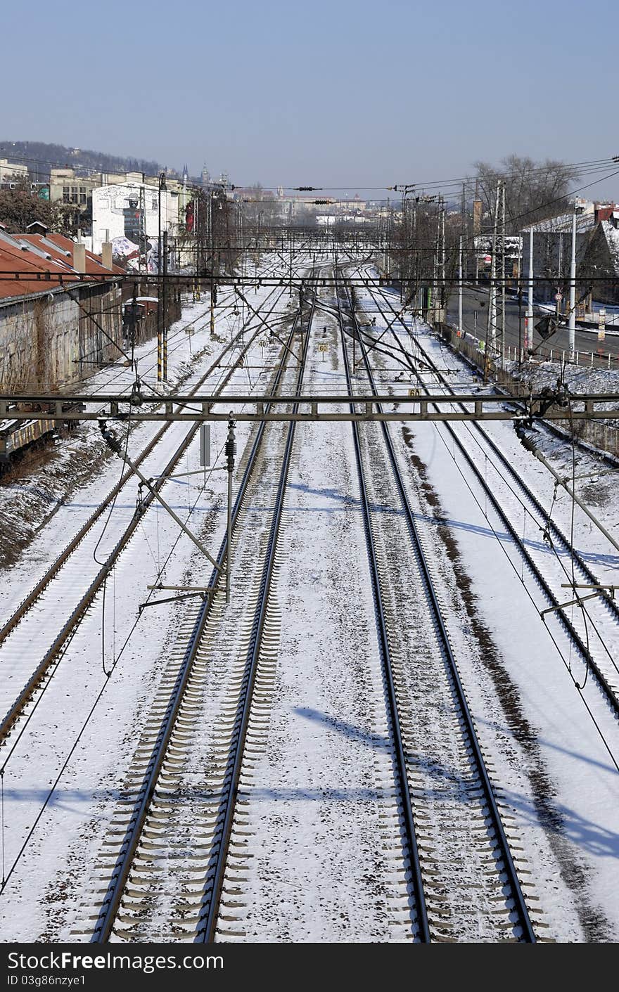 Train tracks in snow covered cityscape