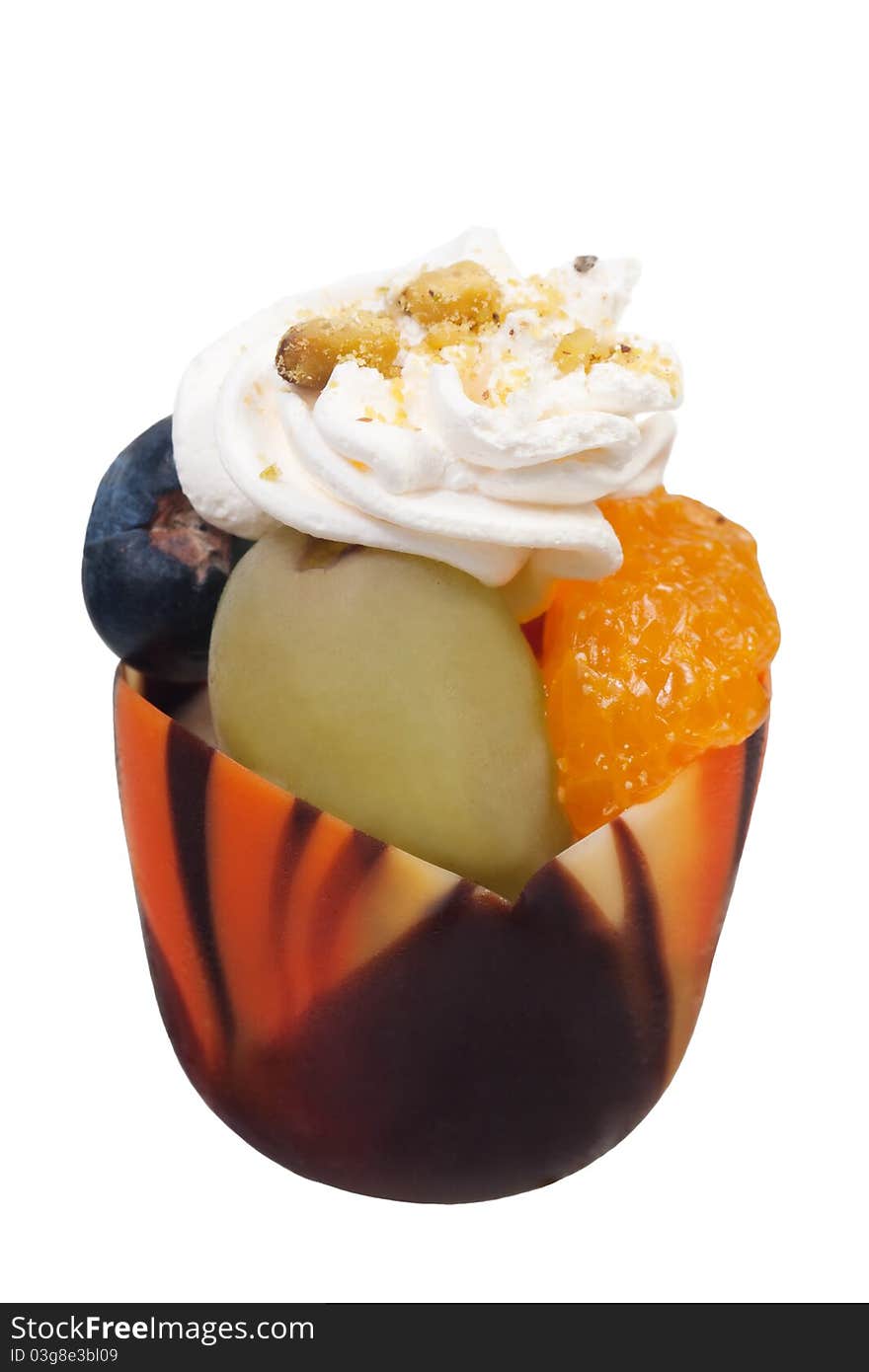 Parfait in a decorative chocolate shell with fruits and whipped cream. Parfait in a decorative chocolate shell with fruits and whipped cream