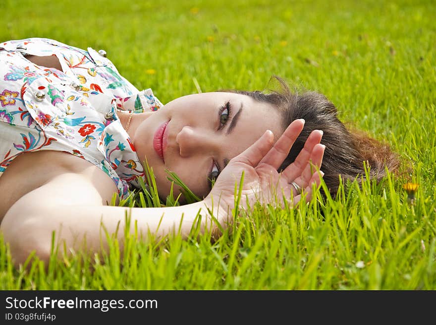 Beautiful young woman lying on the grass