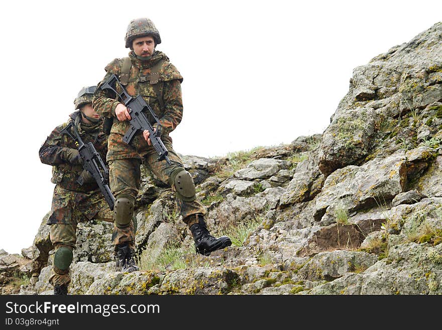 Soldiers moving on mountain with guns