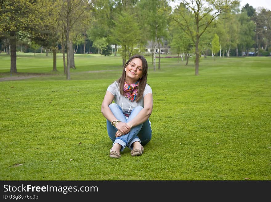 Woman sitting on a green grass