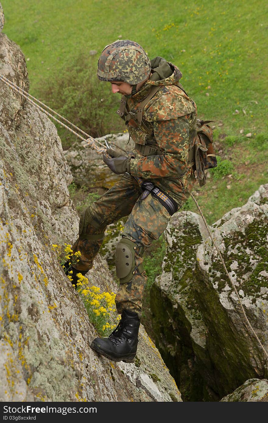 Military man does dangerous rappeling in combative ammunition. Military man does dangerous rappeling in combative ammunition