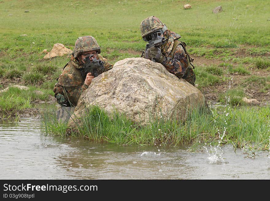 Soldiers covering behind the rock