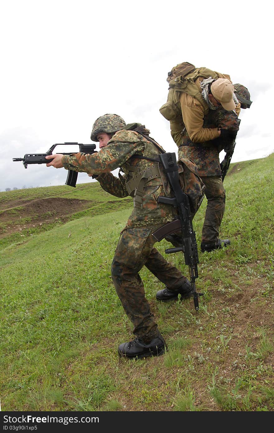 Military men protecting injured soldier. Military men protecting injured soldier