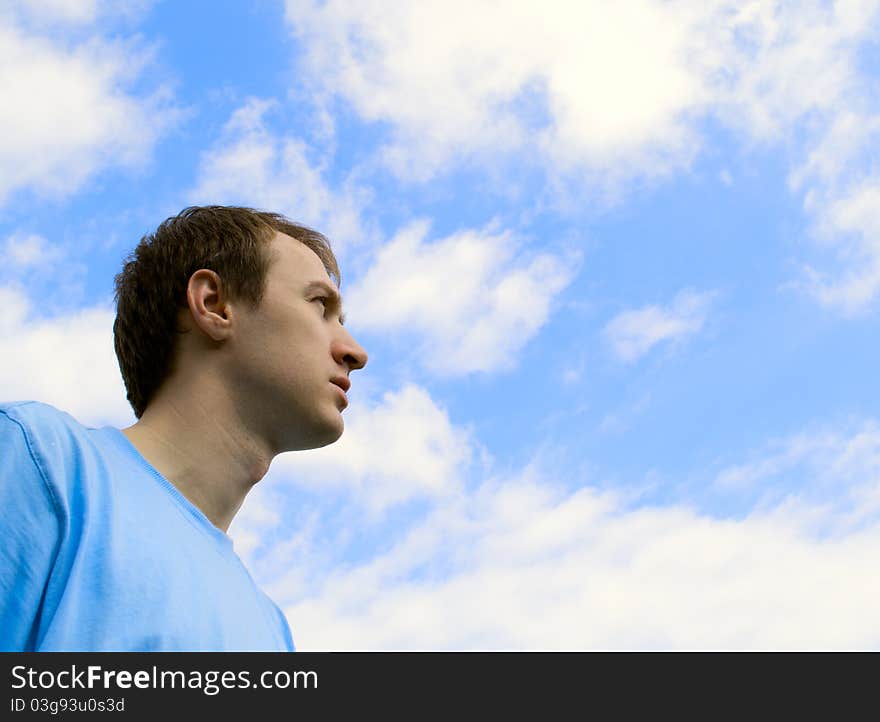 The young man looks at the blue sky