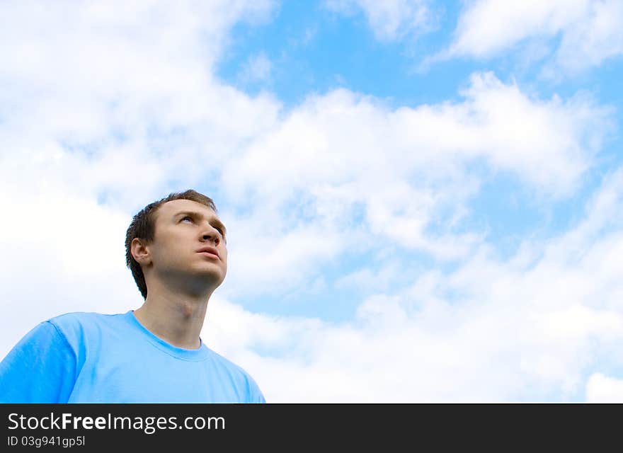 The young man looks at the blue sky