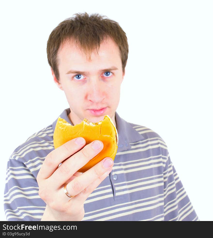 The young man eats a hamburger. Focus on hamburger.