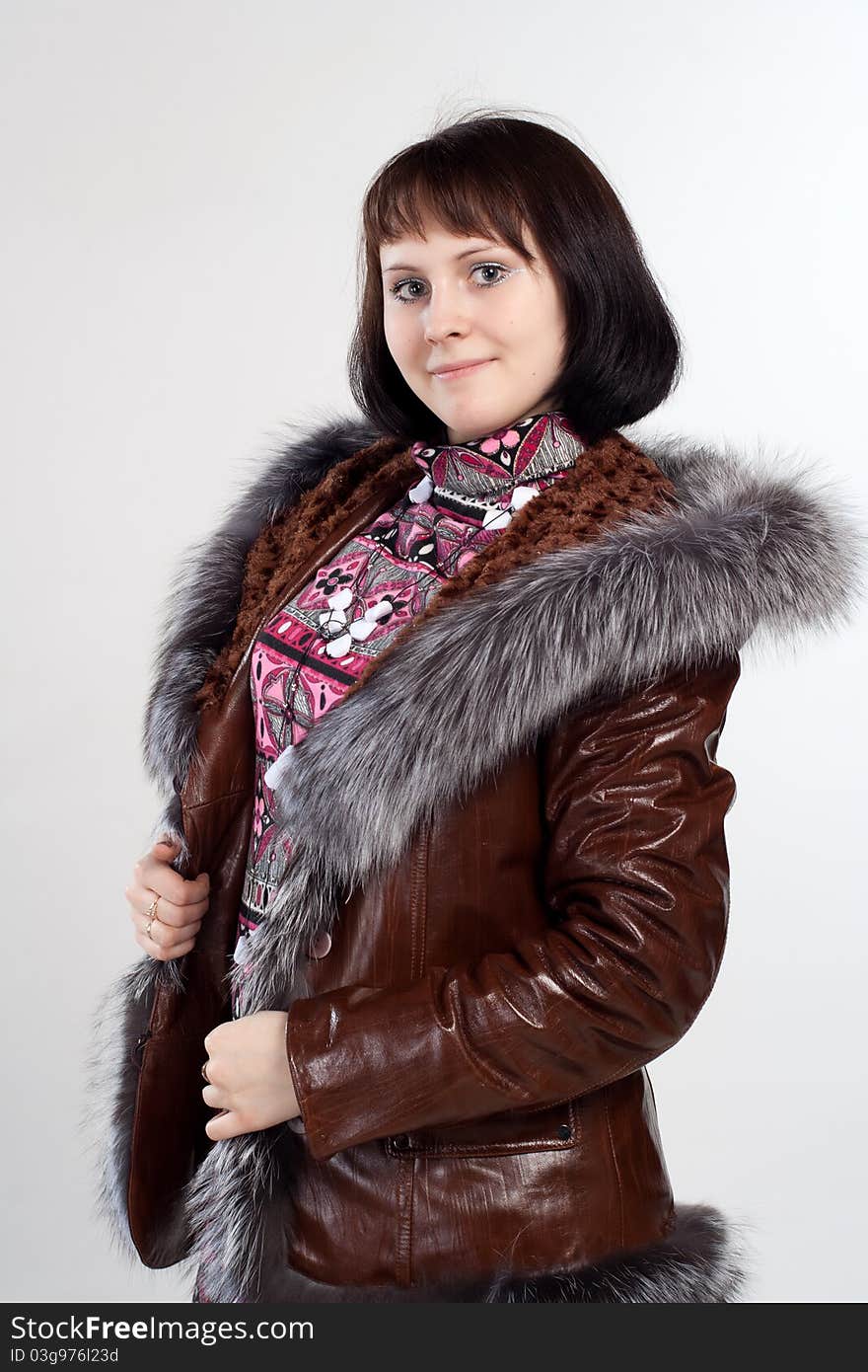 Youth woman staning in coat with fur neck isolated