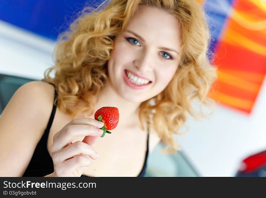 Young woman with strawberry near New car