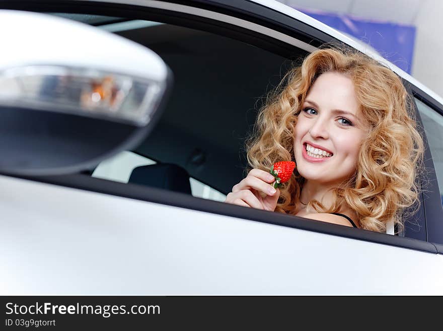 Young Woman With Strawberry In New Car