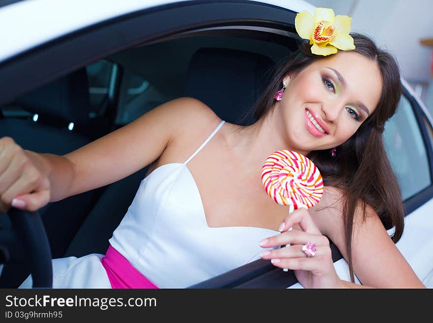 Young woman with candy with New car