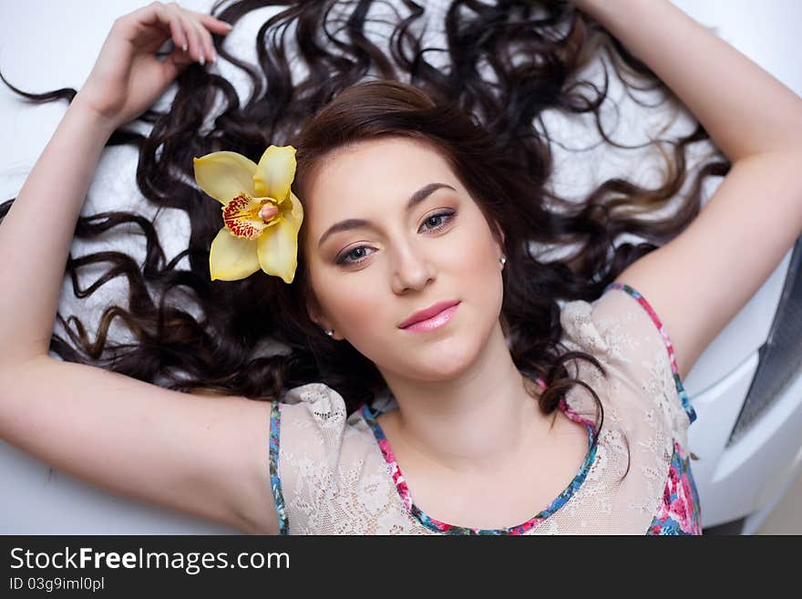 Young woman lying on her back on the hood of the car