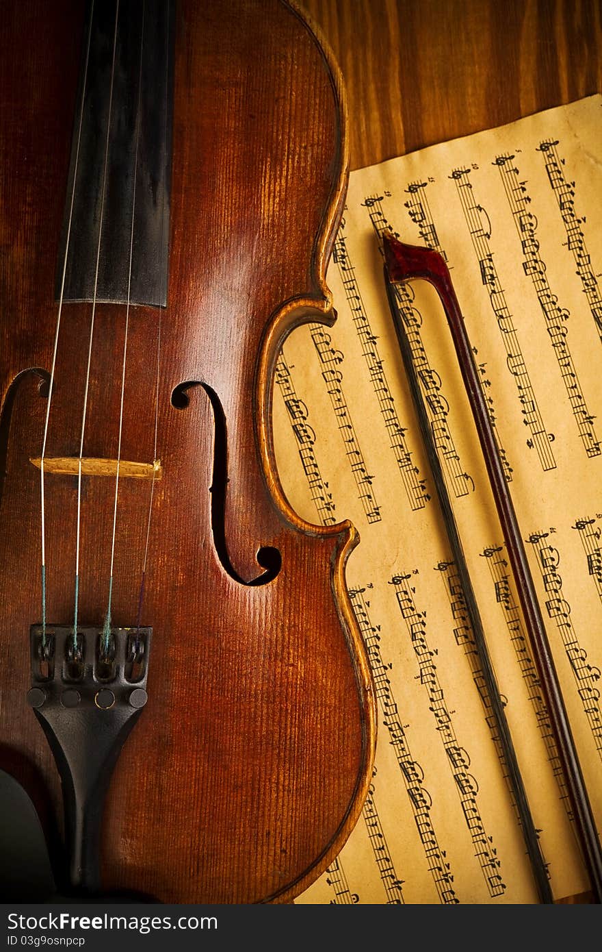 Composition of old used violin and note on wooden board close up. Composition of old used violin and note on wooden board close up