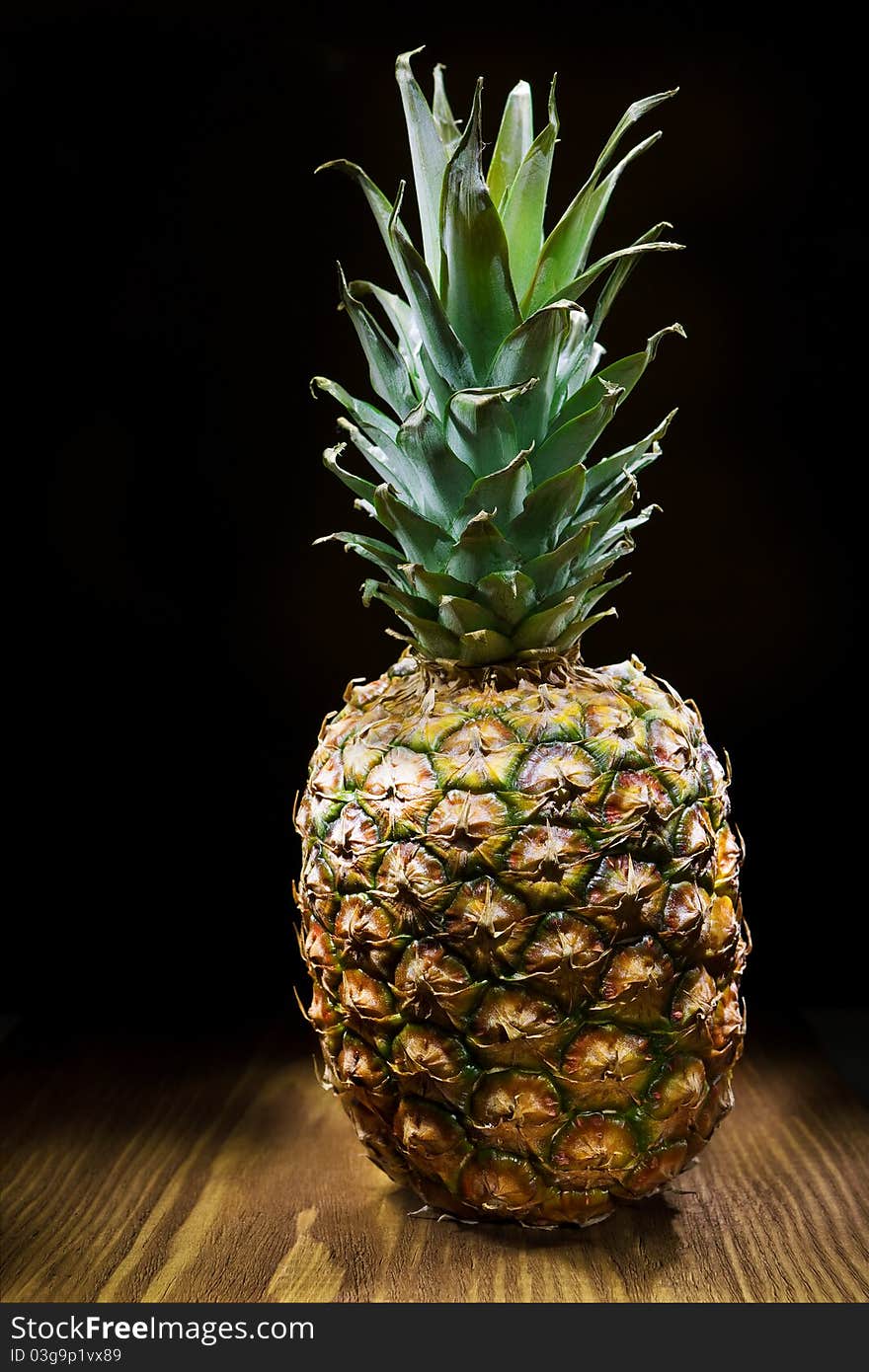 One pineapple on old wooden board