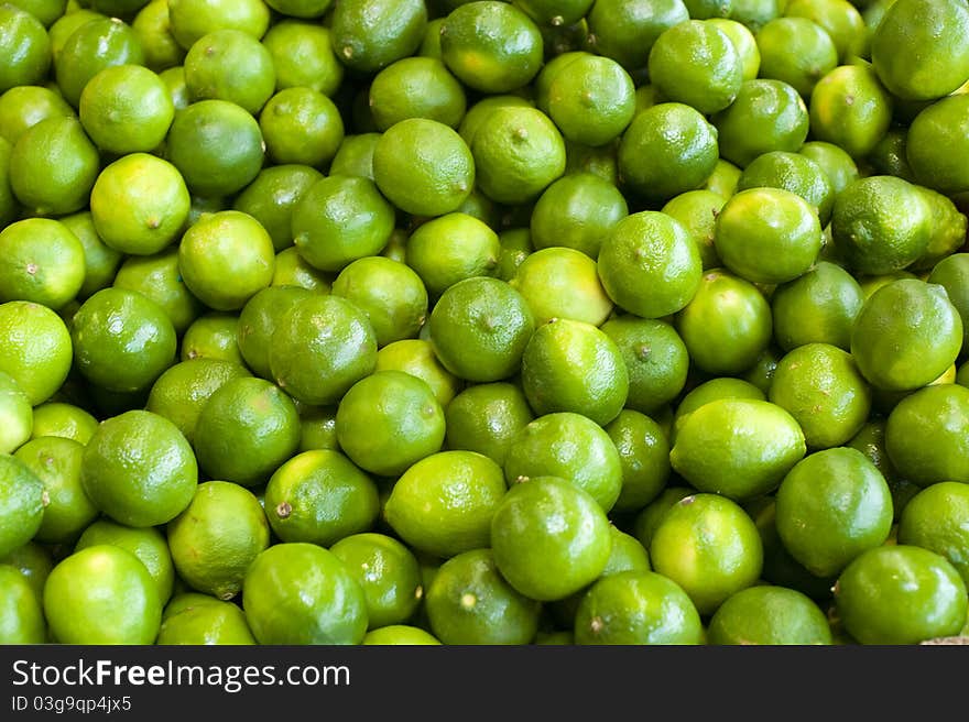 Fresh green limes bunched together at a farm stand. Fresh green limes bunched together at a farm stand