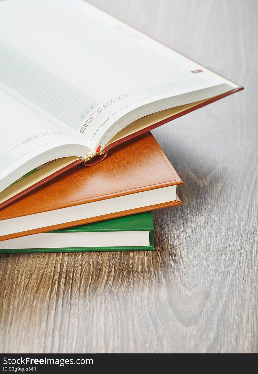 Three notebooks on wooden background