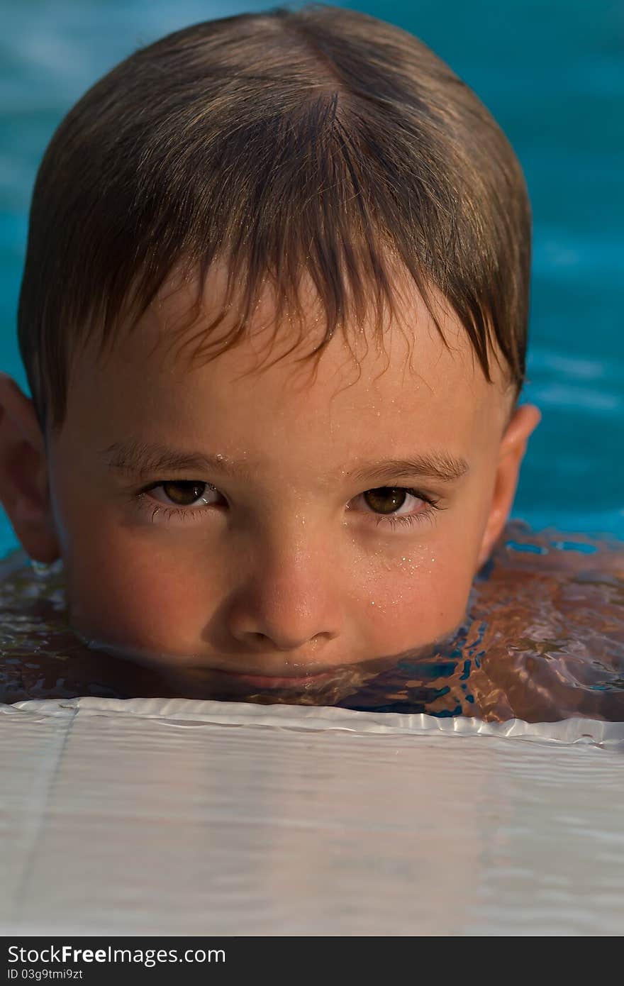 Portrait of a boy in a pool half face in the water. Portrait of a boy in a pool half face in the water