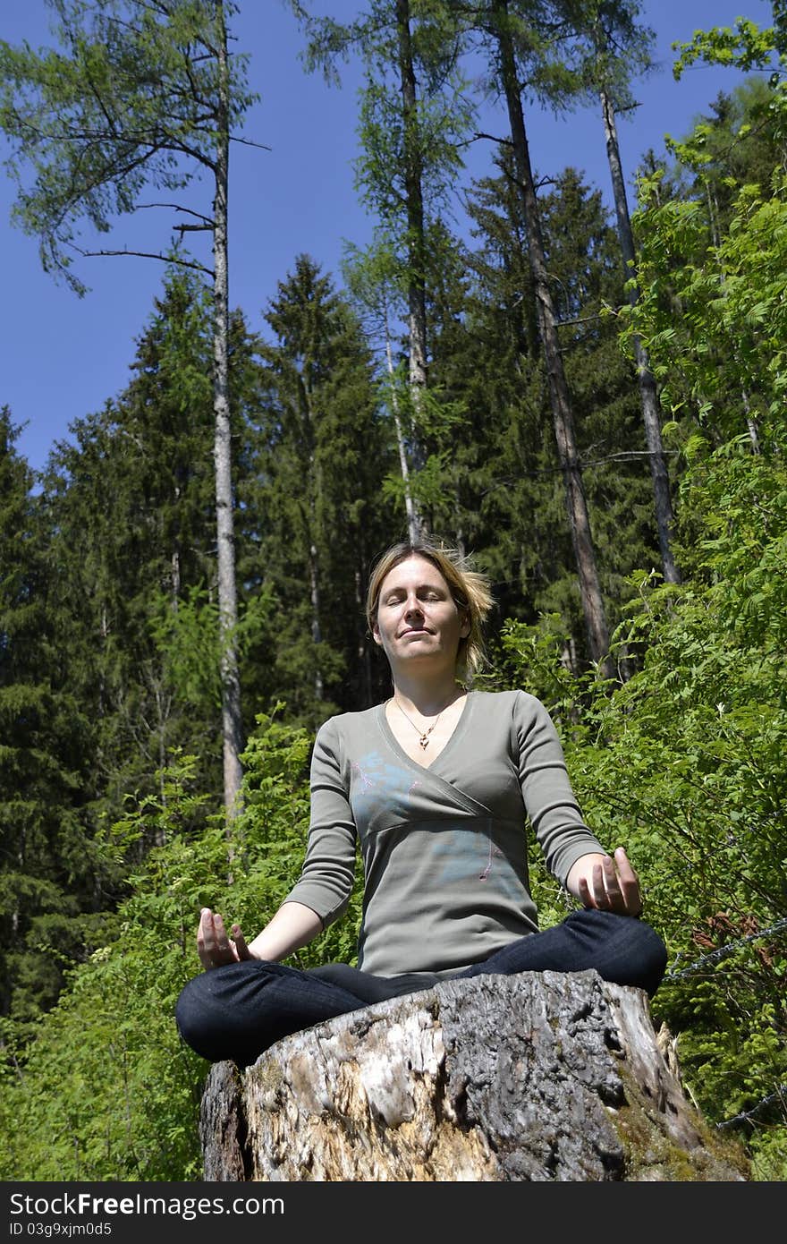 Young woman meditating in the forest. Young woman meditating in the forest.