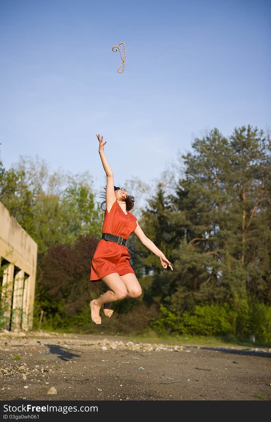 Portrait with happy young woman with red dress jumping. Portrait with happy young woman with red dress jumping