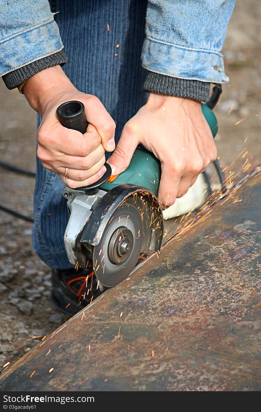 A worker cuts a metal by grinding wheel. A worker cuts a metal by grinding wheel