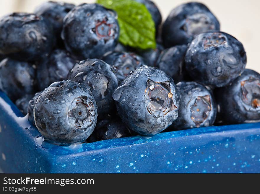 Blueberries in a small blue container. Blueberries in a small blue container