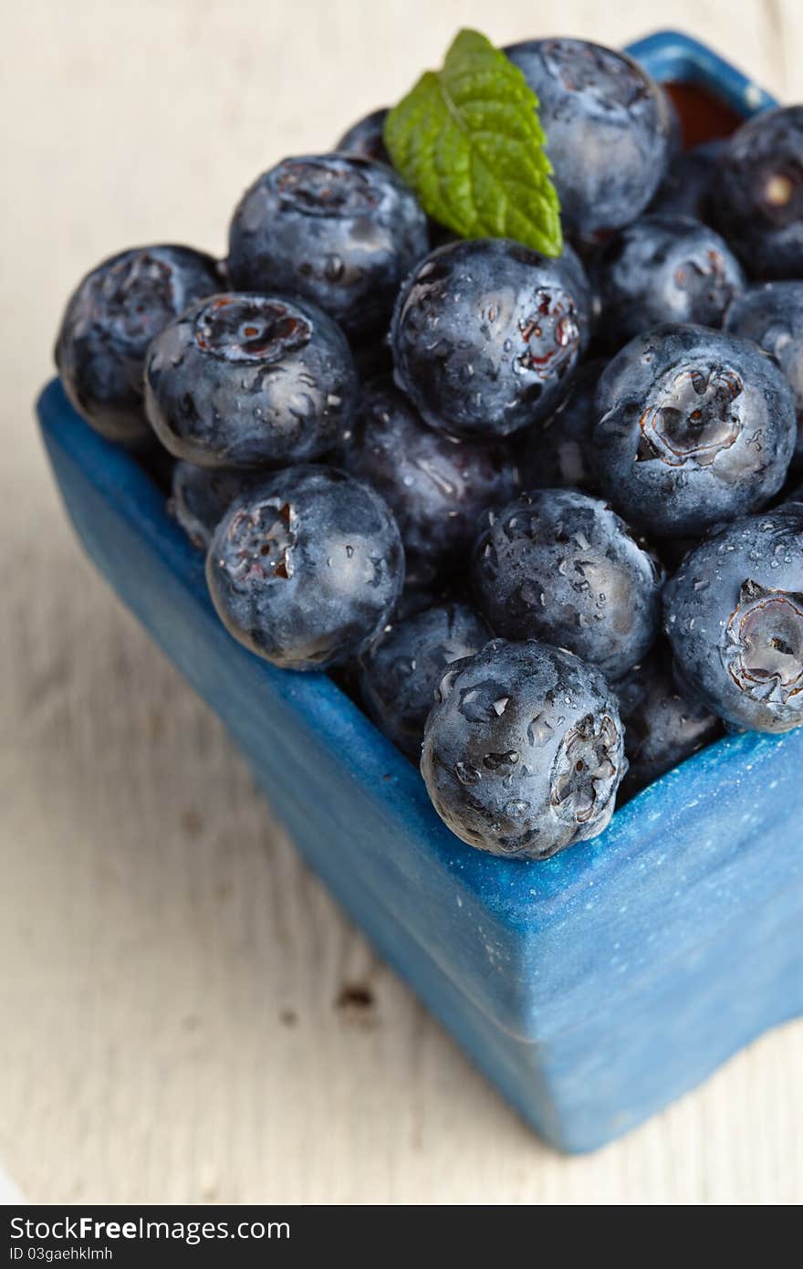 Blueberries in a small blue container. Blueberries in a small blue container