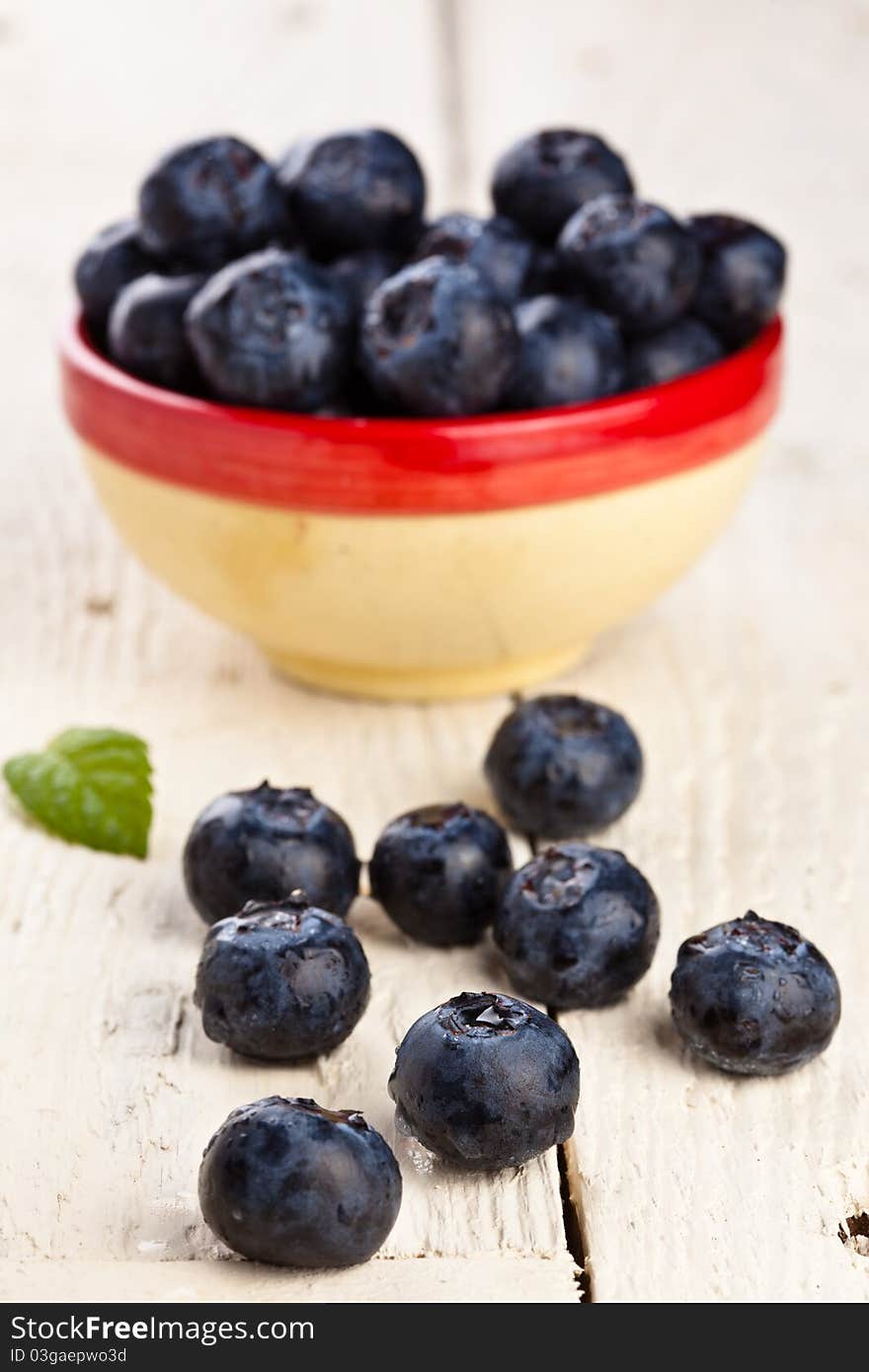 Blueberries in a small container on a wooden table. Blueberries in a small container on a wooden table