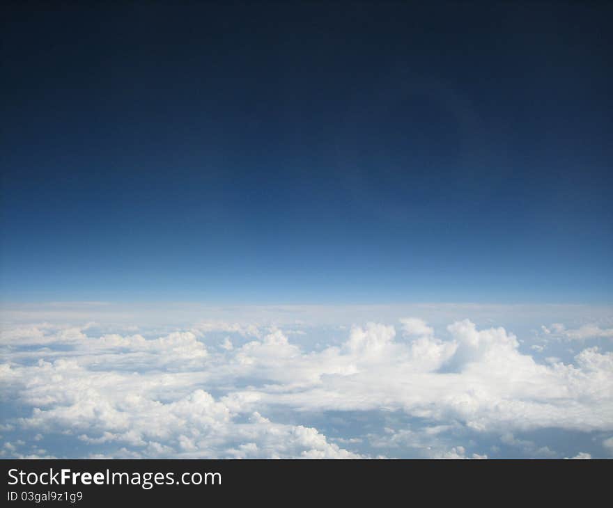 Large white clouds above the horizon seen from a plane