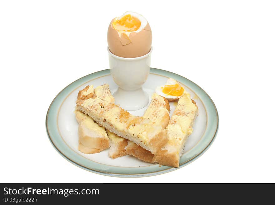 Soft boiled egg with buttered toast soldiers on a plate isolated against white