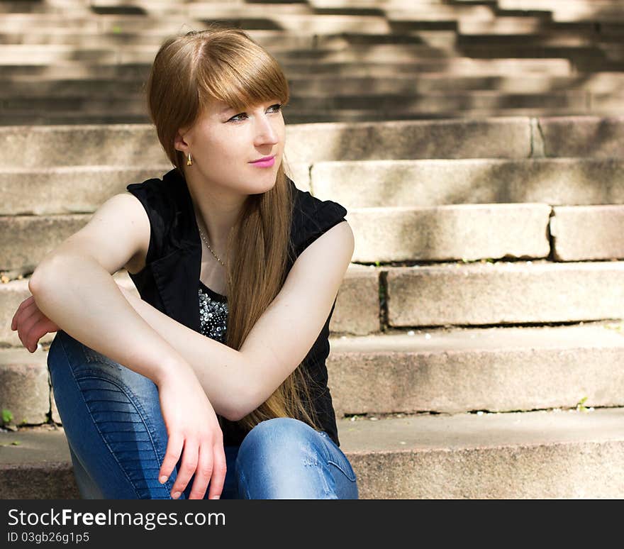 Single beautiful woman relaxing at the staircase. Single beautiful woman relaxing at the staircase