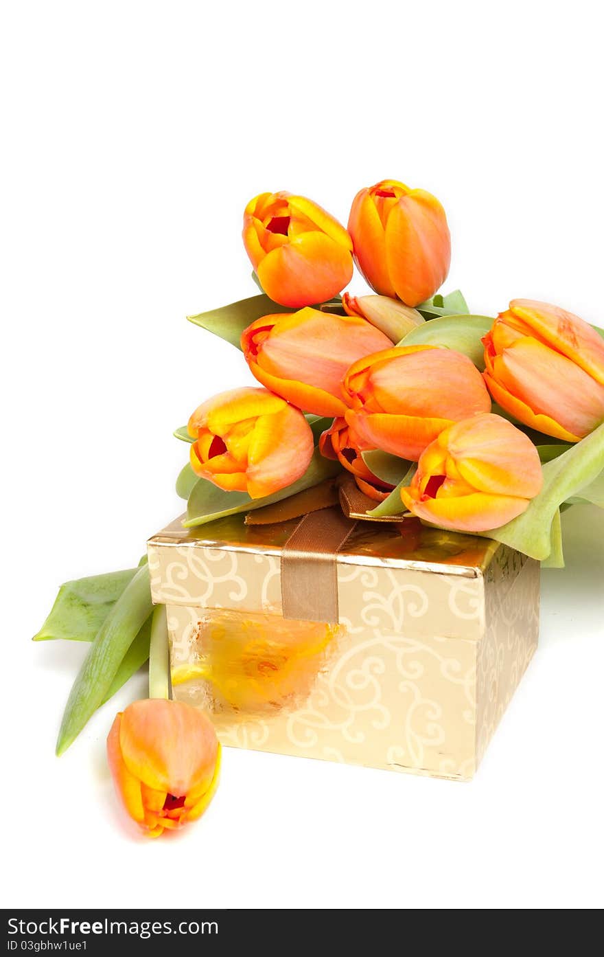 Yellow orange tulips laying on a golden present