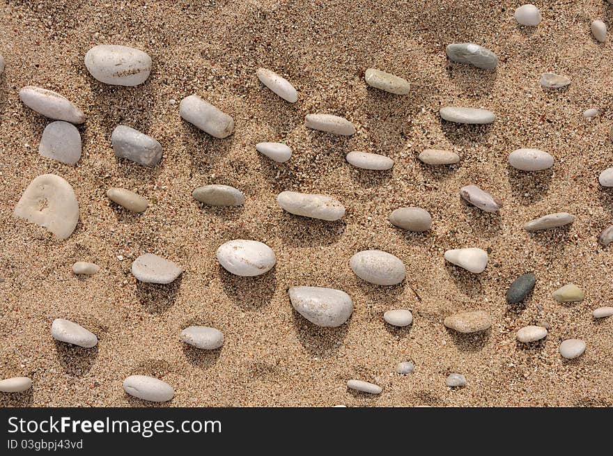 Beach on the summer light closeup with random pebbles. Beach on the summer light closeup with random pebbles