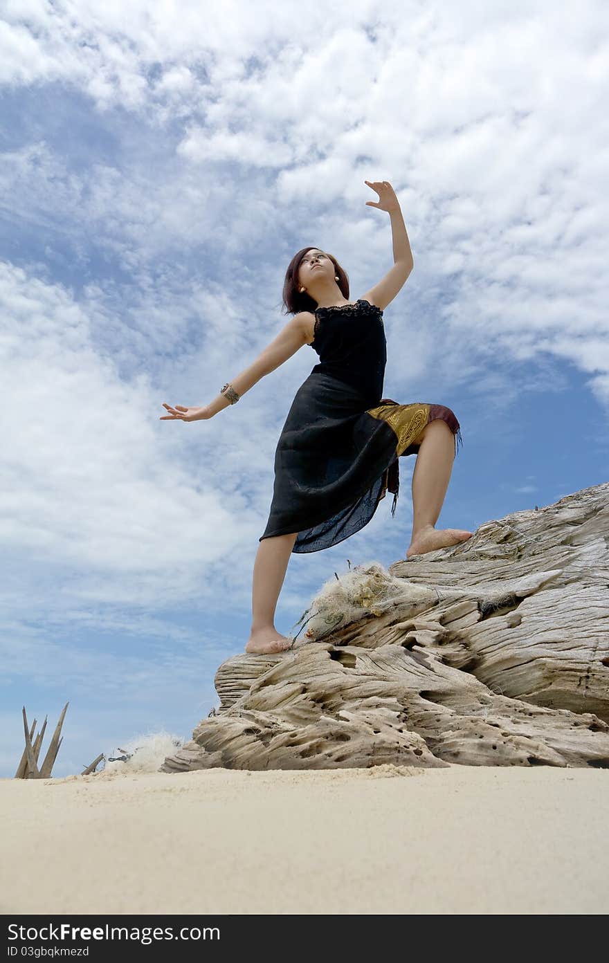 Young woman performs on beach of tropical island during holiday