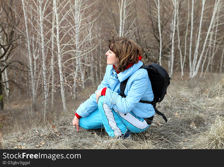 Close-up of the girls profile with backpack on the forest background. Close-up of the girls profile with backpack on the forest background.