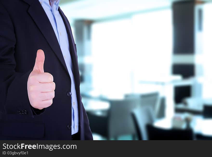 Businessman showing thumb up in front of office