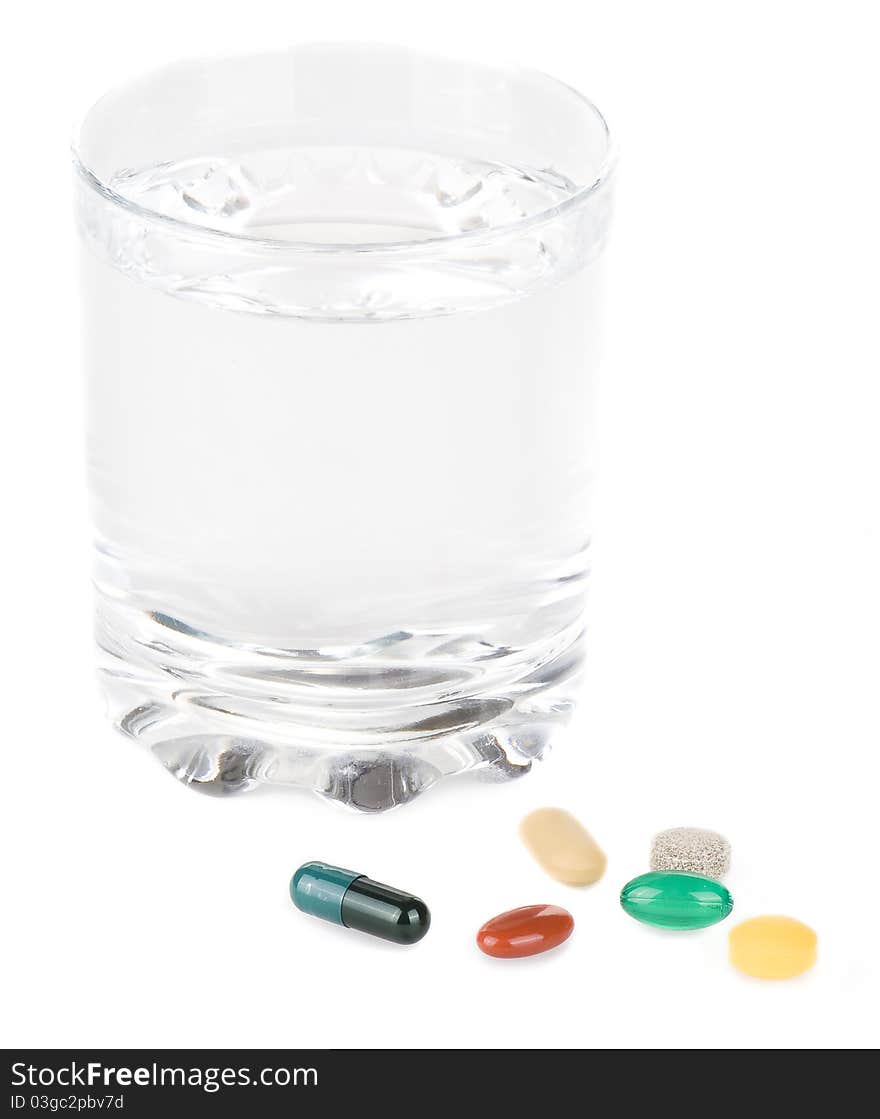 Various pills with glass of water on a white background. Various pills with glass of water on a white background