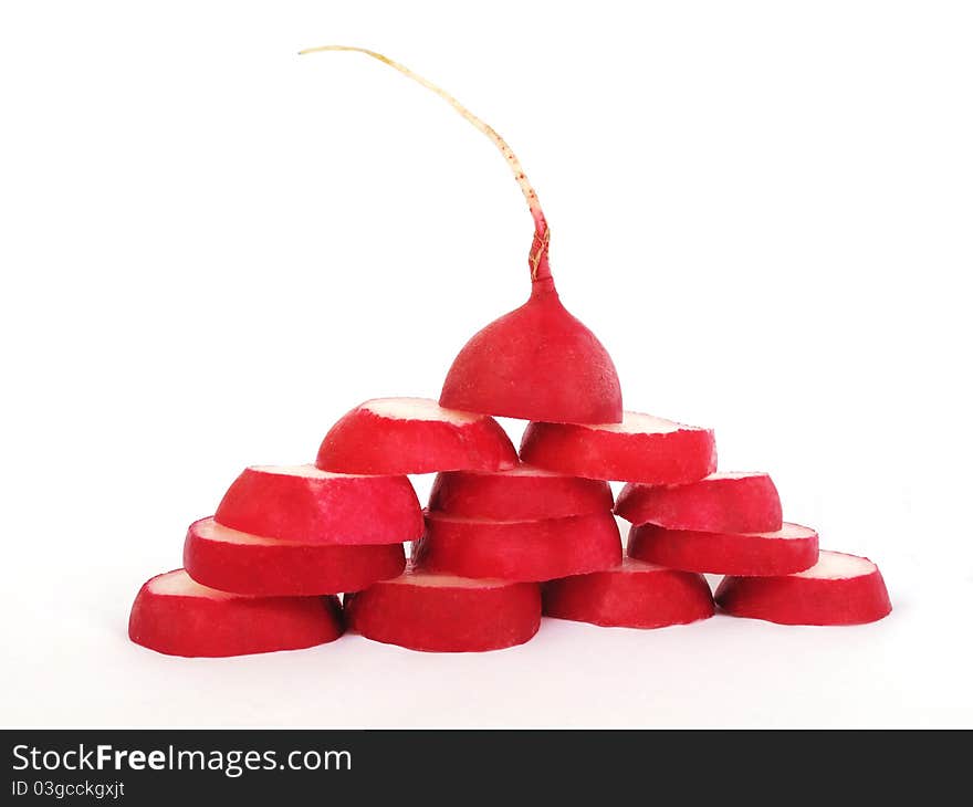 A red radish is cut groups, built as a pyramid on a white background. A red radish is cut groups, built as a pyramid on a white background