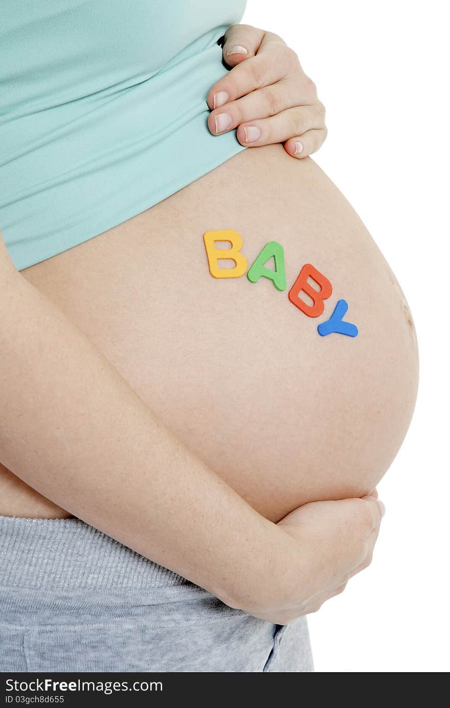 Close up of pregnant ladies tummy- BABY written. Close up of pregnant ladies tummy- BABY written