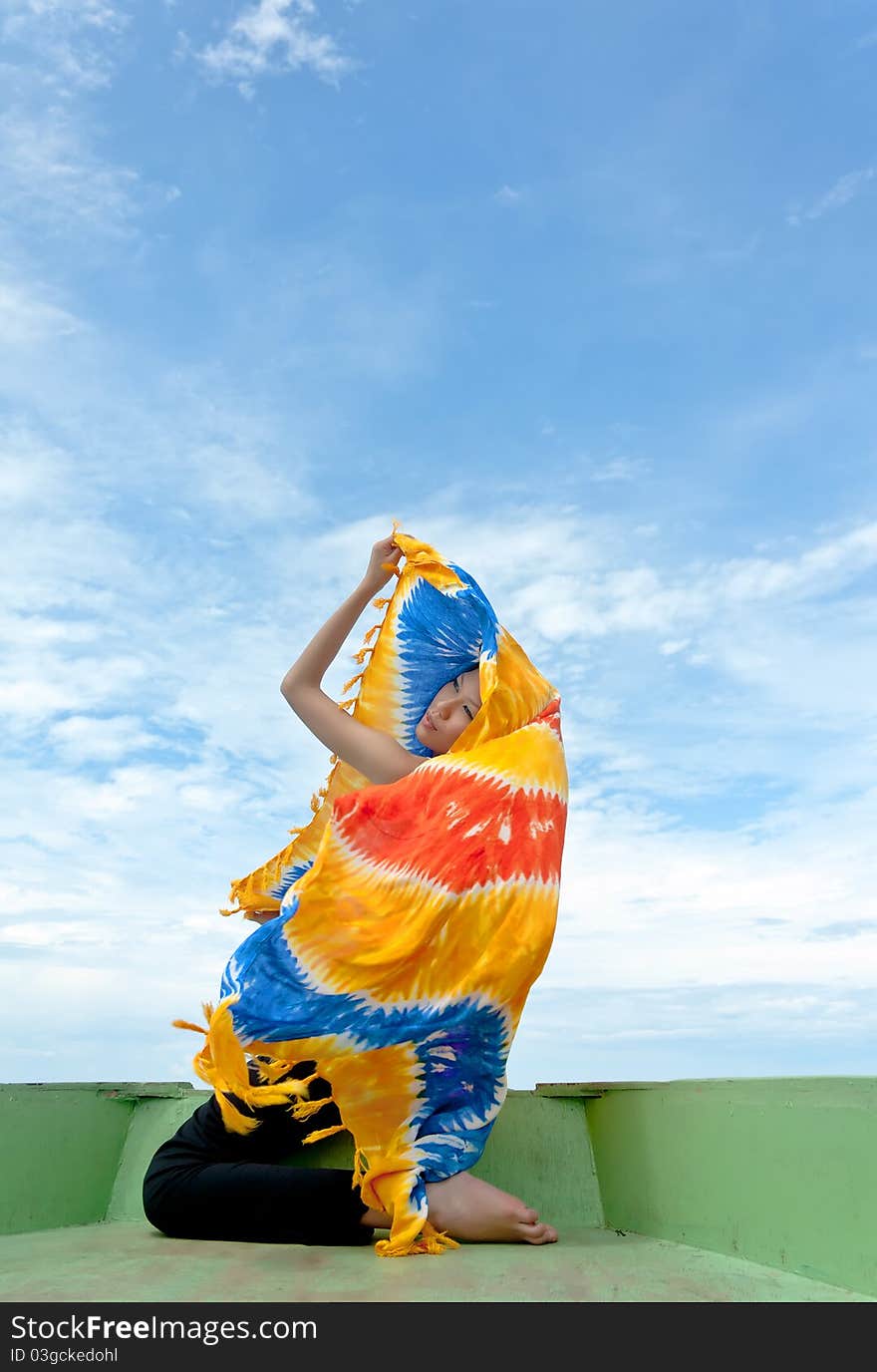 Pretty young sensuality beautiful woman performs with sarong on boat during holiday to beach in paradise