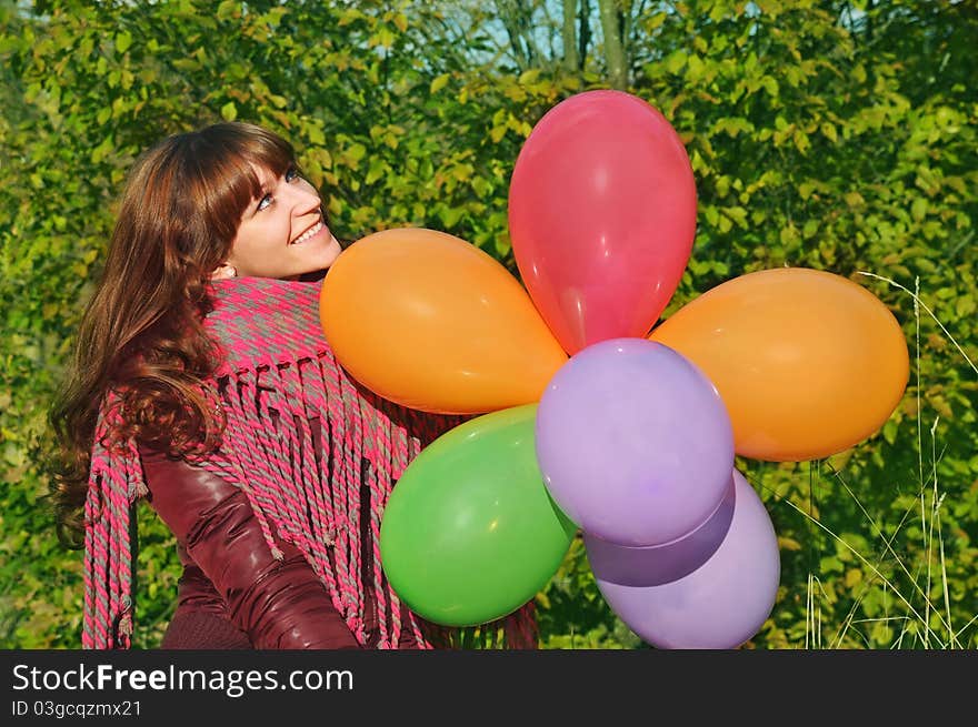 Girl with colorful balloons in park