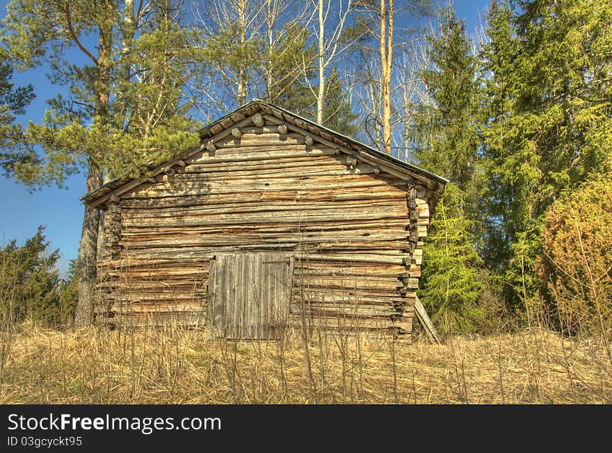 An old wooden country barn in the middle of the forest.