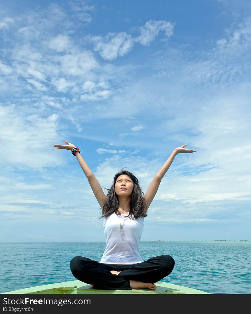 Pretty young sensuality girl performs as yoga move in front of moving boat during holiday