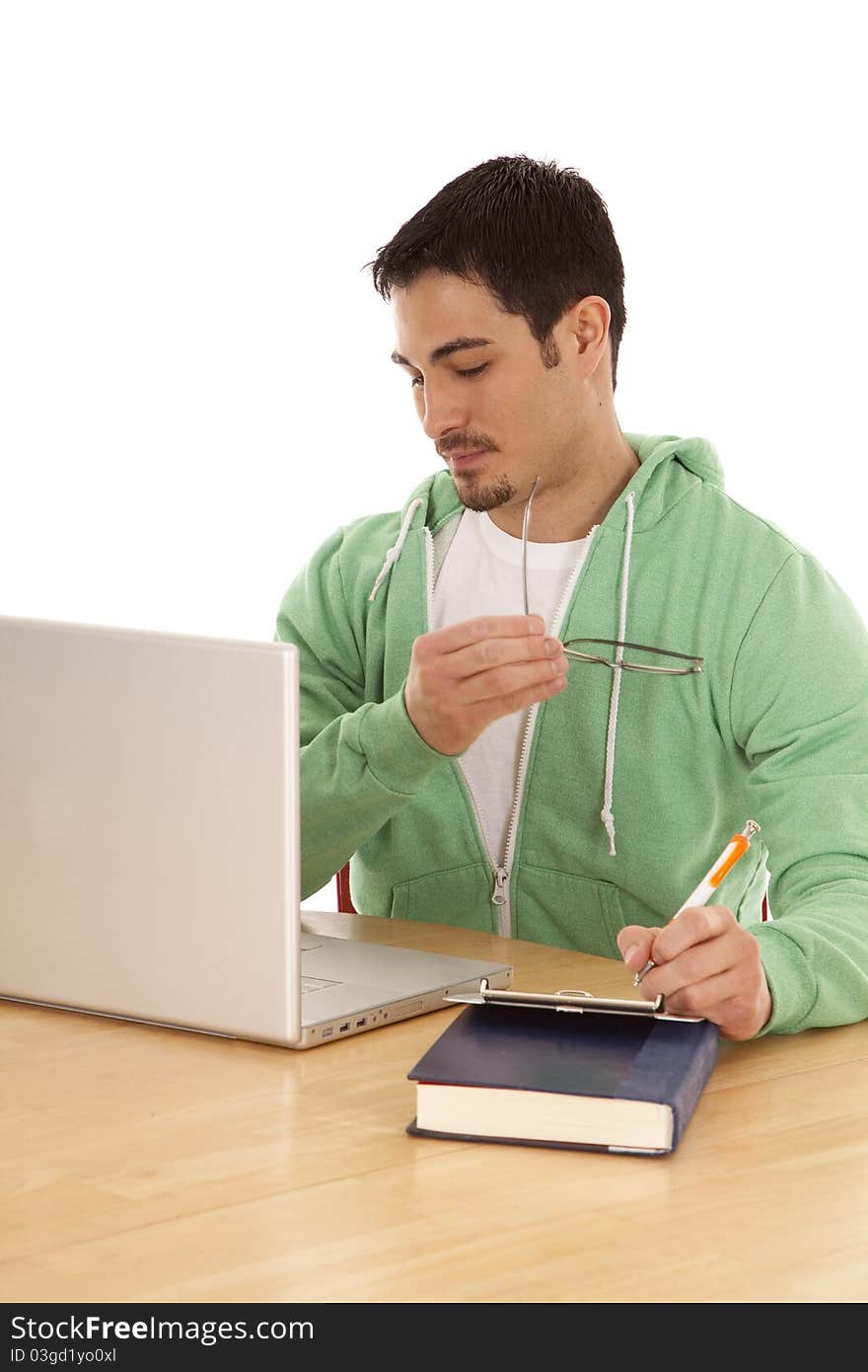 A man is studying at a table with a laptop. A man is studying at a table with a laptop.