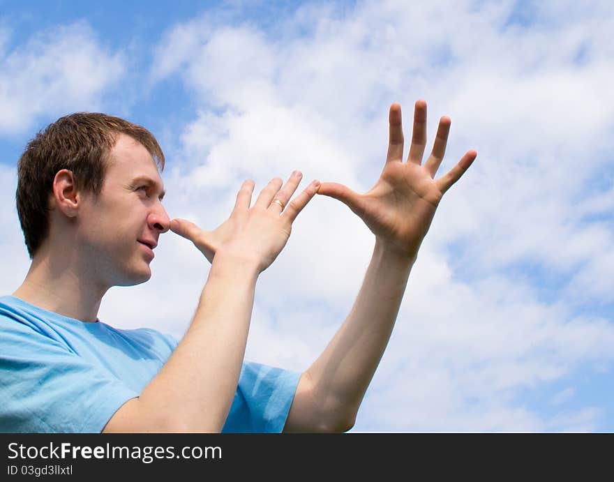 The young man plays about and wriggles against the blue sky. The young man plays about and wriggles against the blue sky