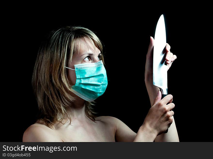 Woman with a knife on dark background