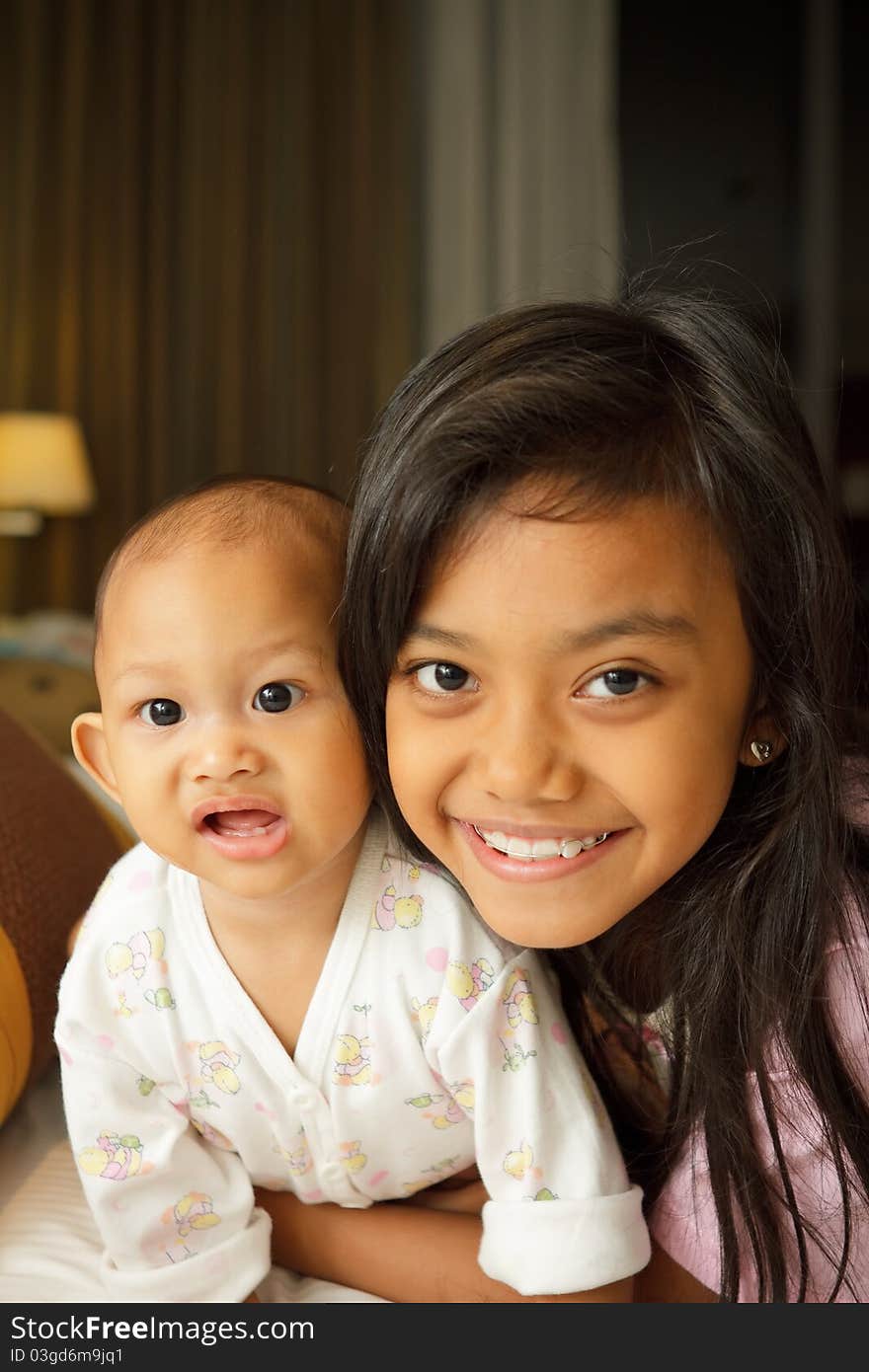 Portrait of asian ethnic little girl and baby on bed. Portrait of asian ethnic little girl and baby on bed