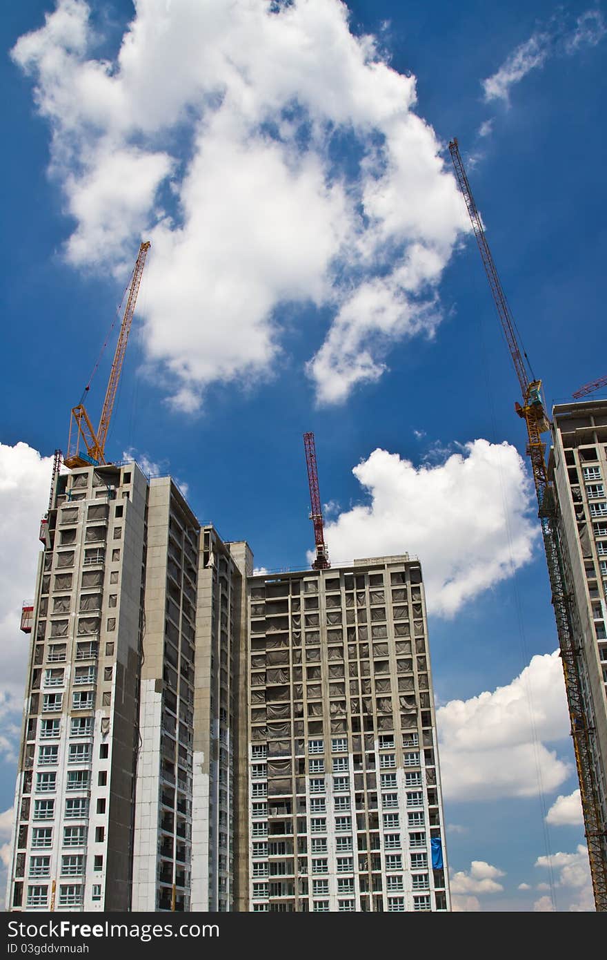 Raw state residential highrise and jib crane over cloudy sky