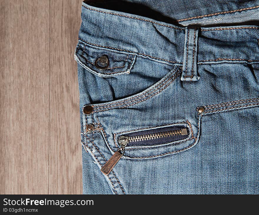 Jeans pocket and zipper on background of wood