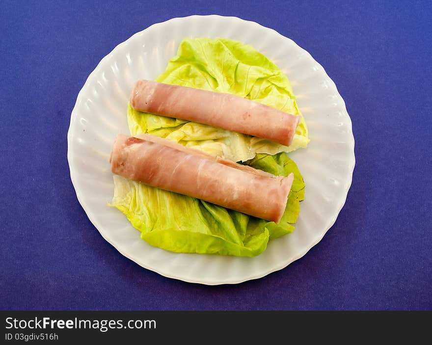 White plate with fresh lettuce and ham. White plate with fresh lettuce and ham